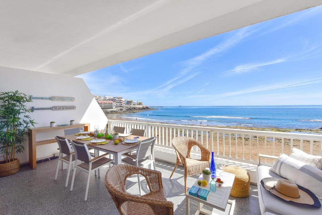 a balcony with a table and chairs and the ocean at El Balcon de Salinetas MF by VillaGranCanaria in Telde
