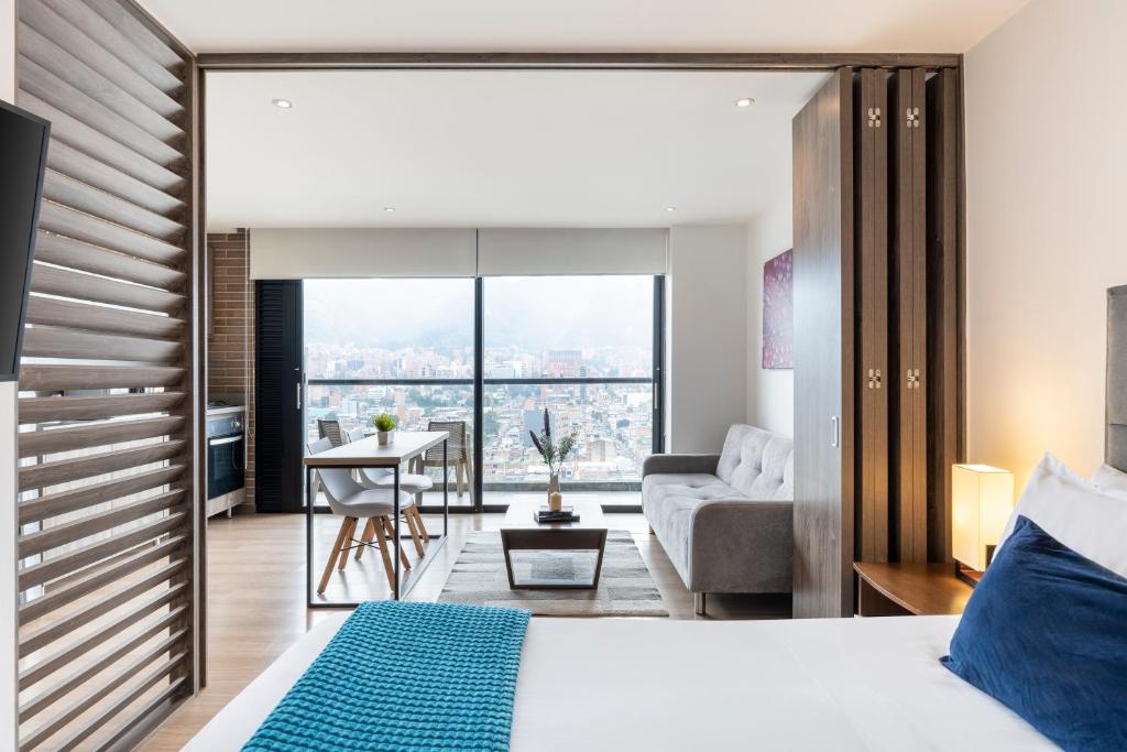 a bedroom with a bed and a living room at 72 HUB Apartments - Great View - Gym - Rooftop in Bogotá