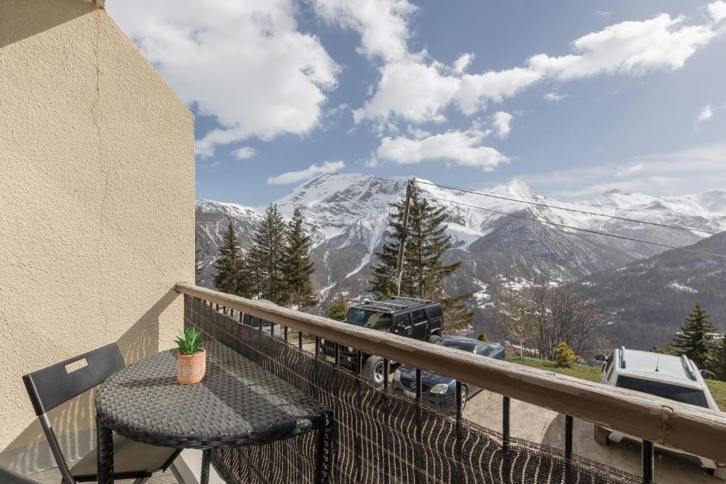 a balcony with a table and a view of a mountain at Studio Alaskan - Studio lumineux vue montagne in Orcières