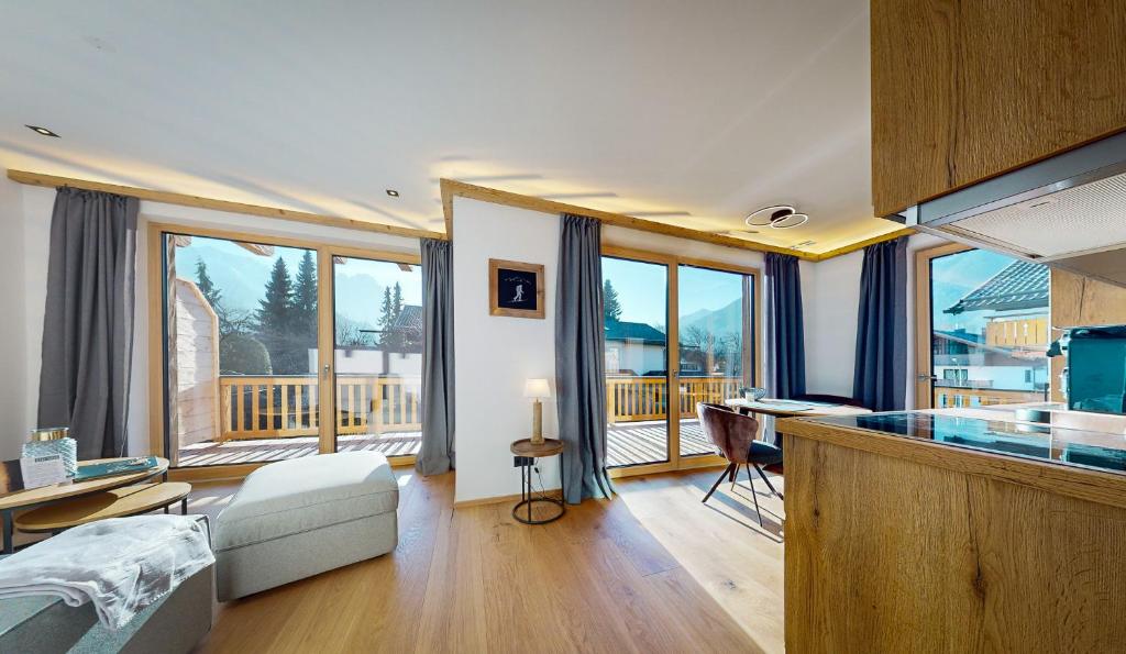 um quarto com uma cozinha com uma secretária e uma varanda em Garmisch Chalets - Wohnung Pflegersee em Garmisch-Partenkirchen