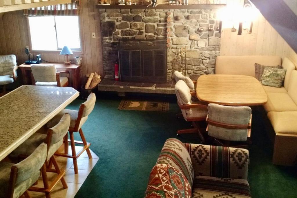 un soggiorno con tavolo e camino di Historic Big Mountain Chalet Upper a Whitefish