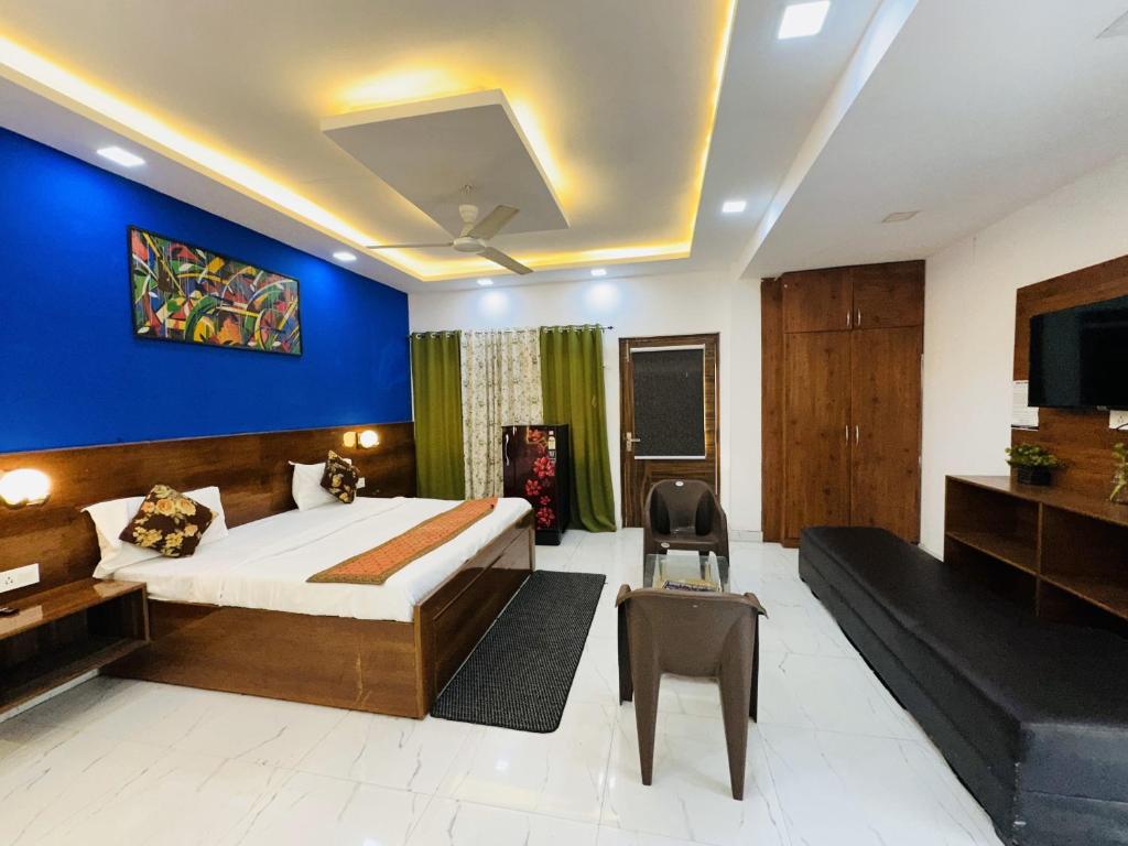 新德里的住宿－Hotel Golden - Premiums Rooms in South Extension，一间卧室设有一张床和蓝色的墙壁