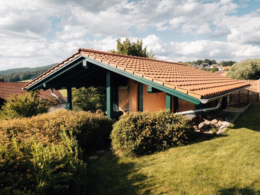 ein Haus mit einem gefliesten Dach im Hof in der Unterkunft Holiday home with whirlpool and sauna in Viechtach in Viechtach