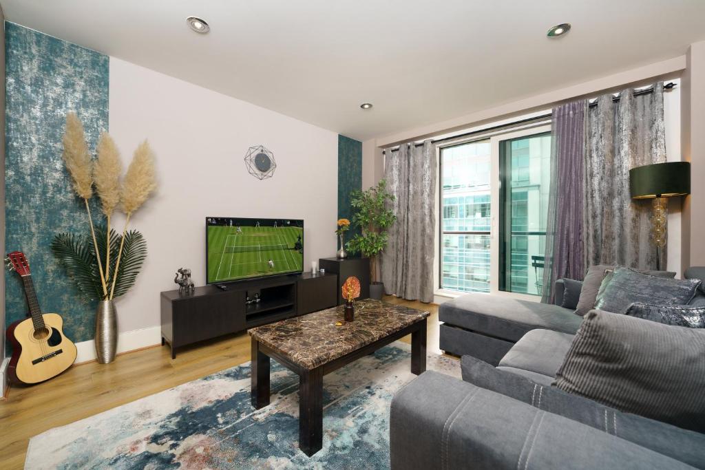 a living room with a couch and a tv at St George Wharf in London