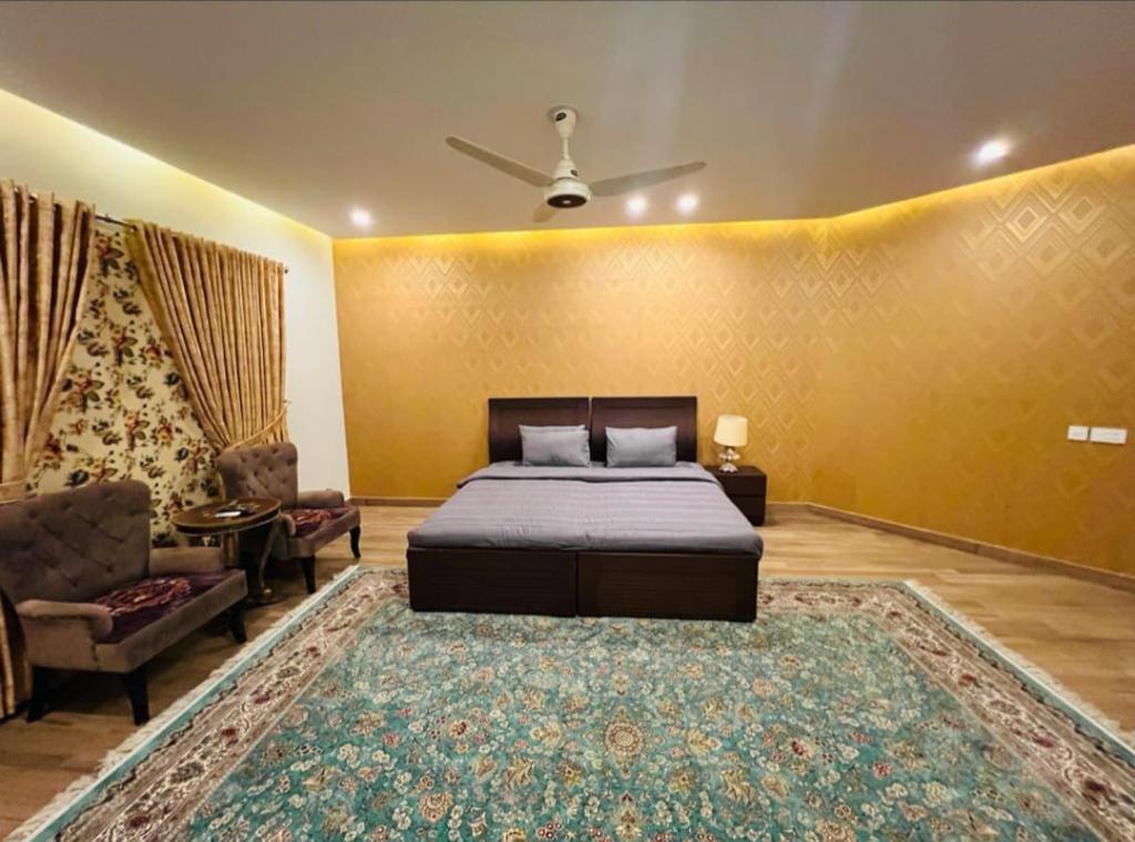 a bedroom with a bed and a couch and a rug at Pearl Executive Villa Islamabad in Islamabad