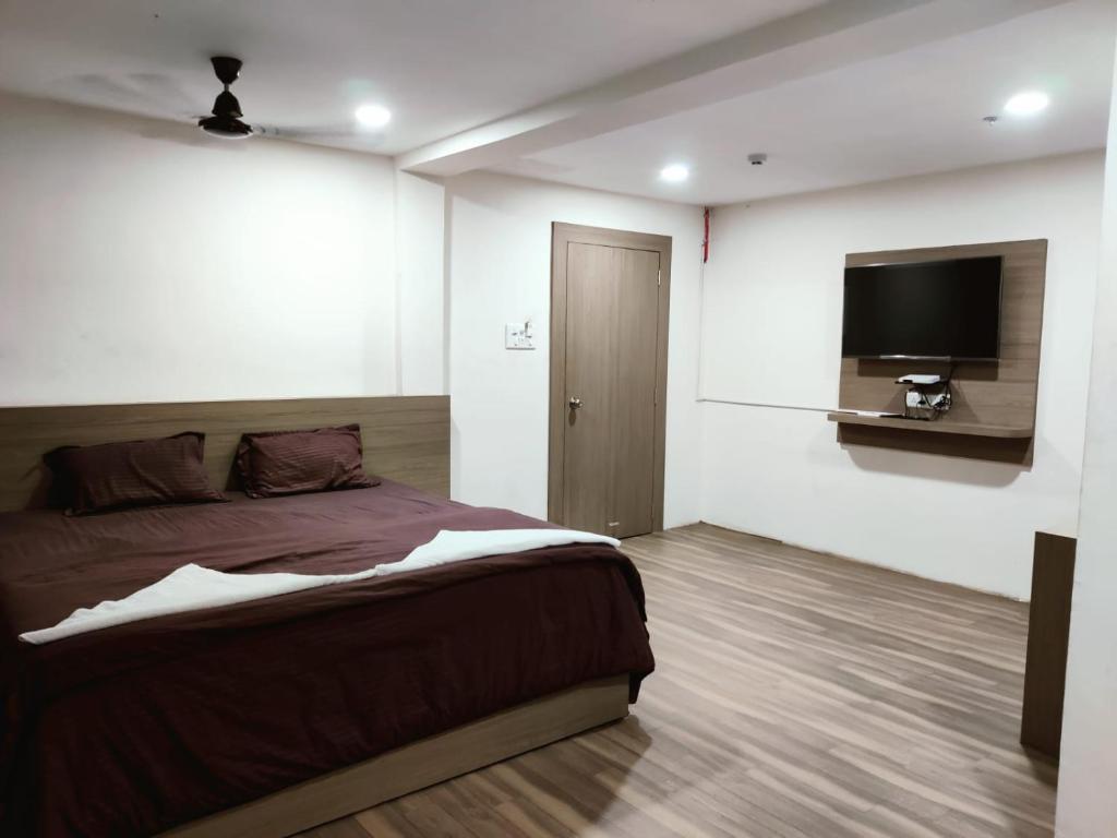 a bedroom with a bed and a flat screen tv at HOTEL NEW RATNAKAR in Daman