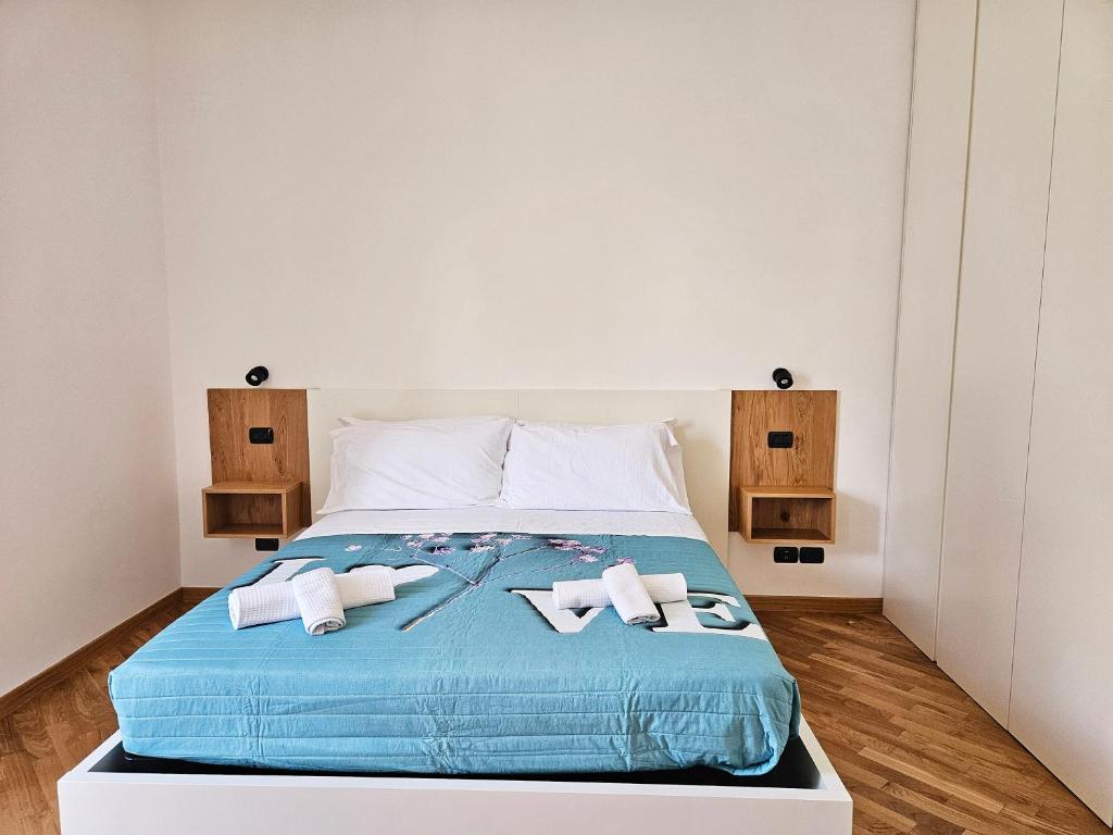 a large bed with blue sheets and white pillows at La Vispa Teresa in Vasto
