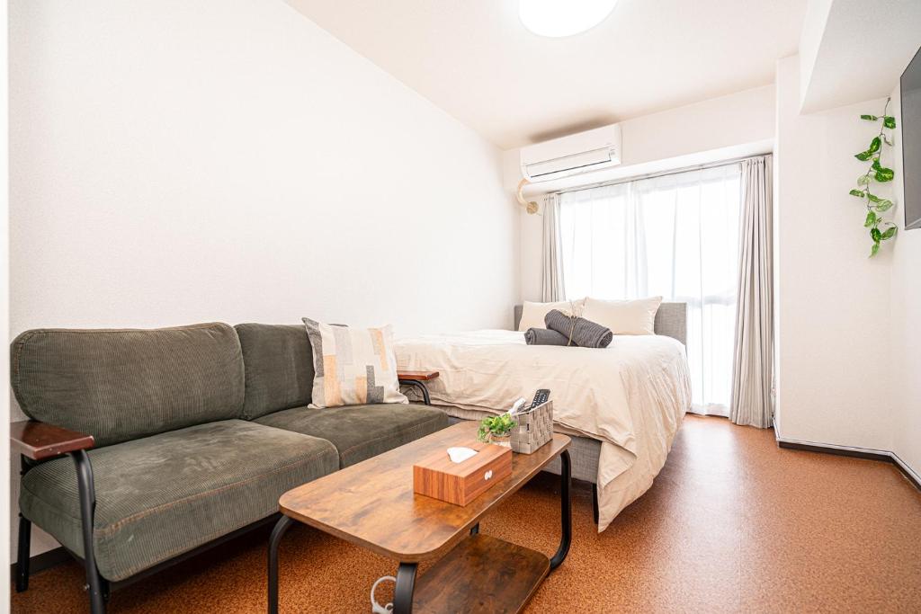 ein Wohnzimmer mit einem Sofa und einem Tisch in der Unterkunft 新宿歌舞伎町東新宿站3分钟，徒步伊势丹4分钟免费Wi-Fi！ in Tokio