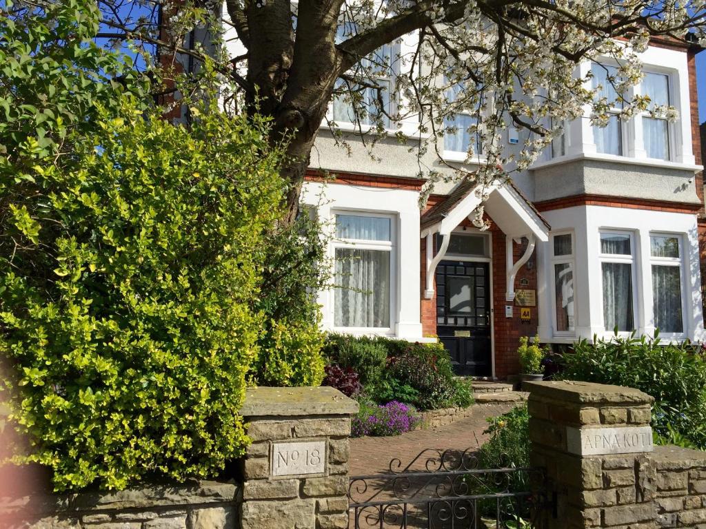 una casa bianca con una panchina davanti di Croham Park B&B - Free Parking & Wi-Fi a Croydon