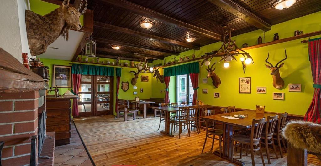 restauracja ze stołami i krzesłami w pokoju z żółtymi ścianami w obiekcie Penzion Myslivna w mieście Velký Újezd
