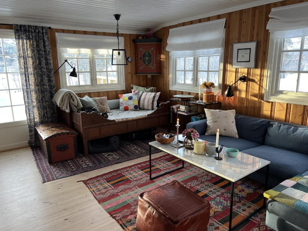 een woonkamer met een blauwe bank en een tafel bij Cozy cabin in the center of Geilo in Geilo