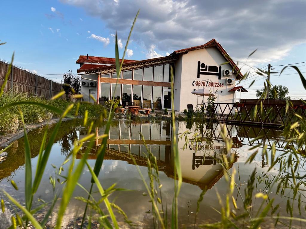 una casa se refleja en un cuerpo de agua en Megnyugtat-lak Apartmanház en Demjén