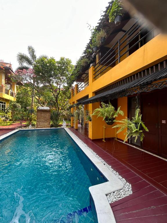 a swimming pool in front of a building at Lamduan Boutique Homestay in Chiang Mai