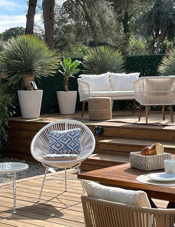 d'une terrasse avec des chaises, une table et un canapé. dans l'établissement Maison élégante & cozy, 5mn des plages & St Tropez, à Gassin