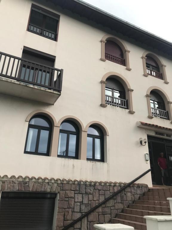 - un bâtiment blanc avec des fenêtres et des escaliers noirs dans l'établissement Appartement lumineux st Jean de luz, à Saint-Jean-de-Luz