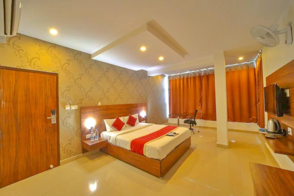 um quarto com uma cama grande num quarto em Aero Hotel em Yelahanka