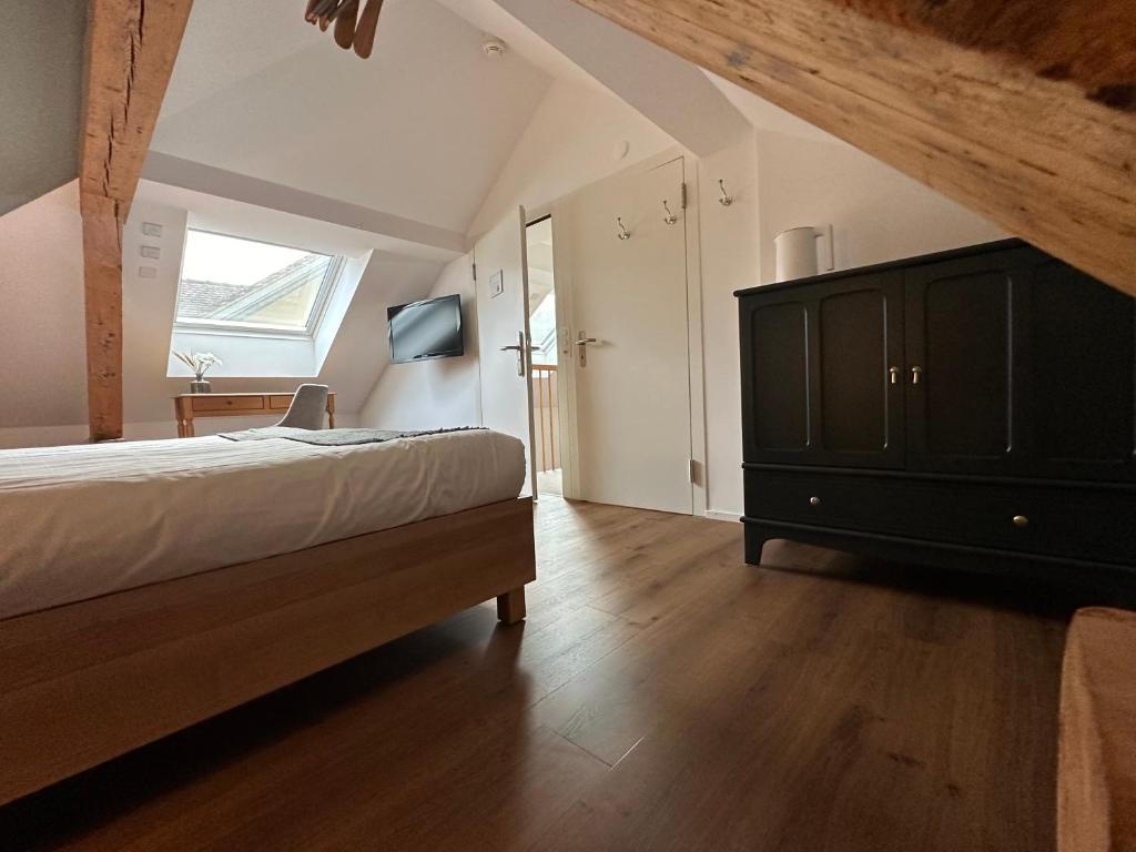 a bedroom with a bed and a dresser and a window at Peterhof Sarnen in Sarnen