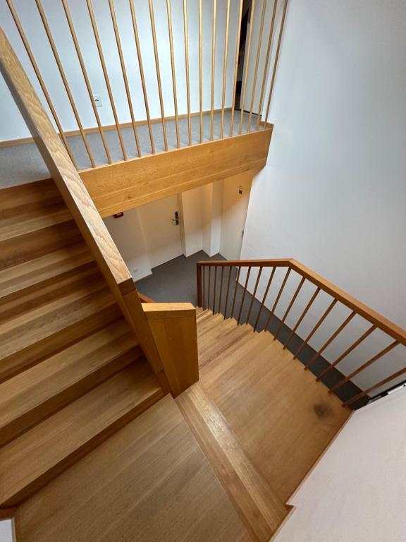 a wooden staircase with a wooden rail and wooden floor at Peterhof Sarnen in Sarnen