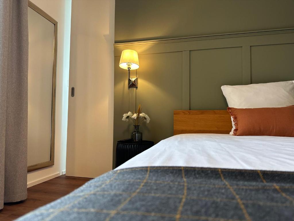 a bedroom with a large bed and a lamp at Peterhof Sarnen in Sarnen