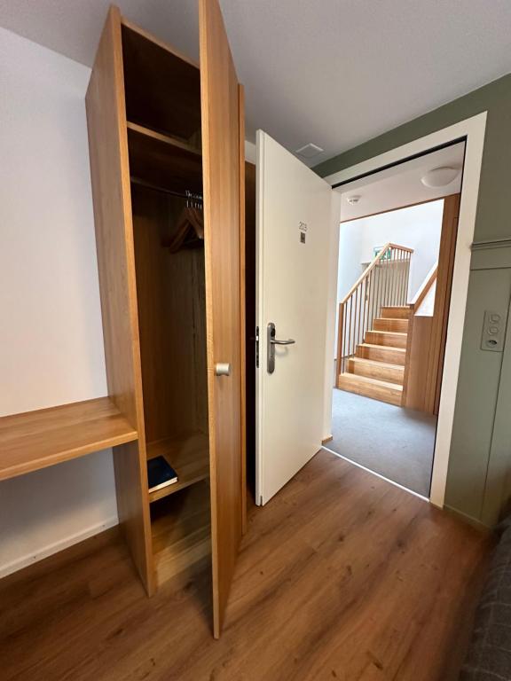 a hallway with an open door and a staircase at Peterhof Sarnen in Sarnen