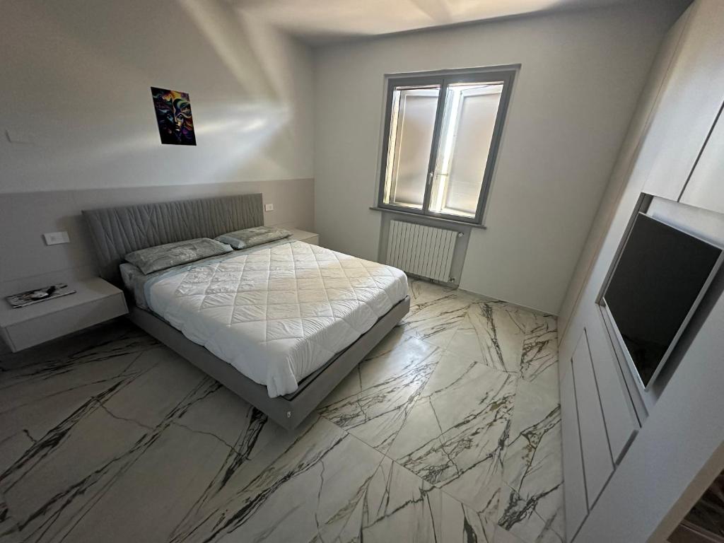a bedroom with a bed and a television on a marble floor at Villa Alberto & Ilaria in Parma