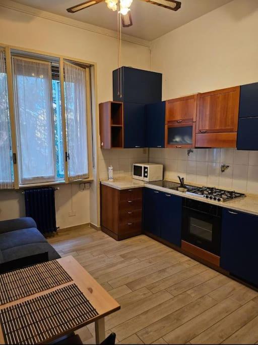 eine Küche mit blauen Schränken und einem Tisch darin in der Unterkunft Liberty Apartment in Mailand