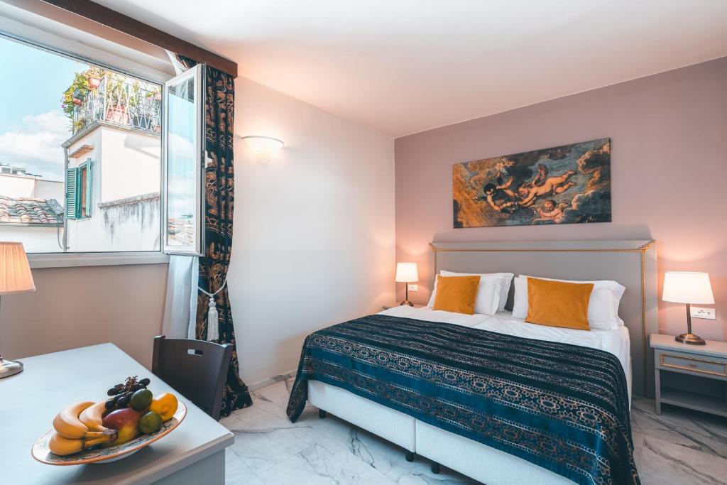 佛羅倫斯的住宿－帕拉索本齊酒店，一间卧室配有一张床,桌上放着一碗水果