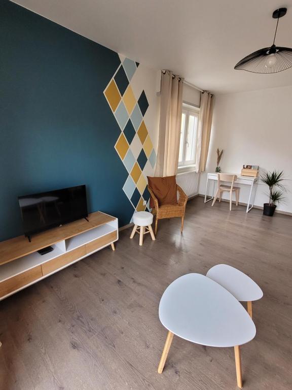 - un salon avec une télévision, des tables et des chaises dans l'établissement Charmante maison à Stotzheim, 1 à 6 personnes, à Stotzheim