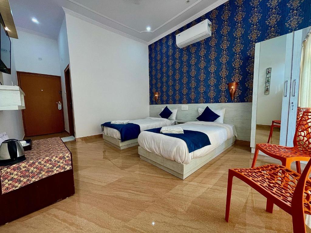 La Curcuma Luxury Homestay في خاجوراهو: غرفة فندقية بسريرين واريكة