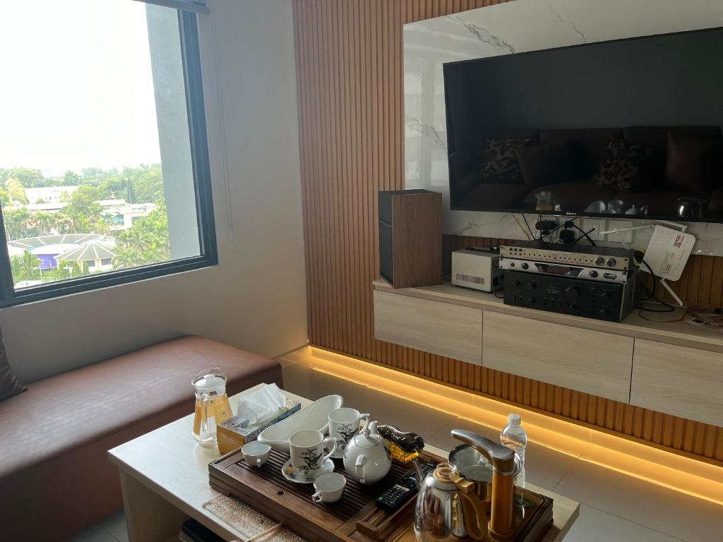 een woonkamer met een televisie en een salontafel bij Khu Nghĩ Dưỡng Emerald Golf View in Thuan An