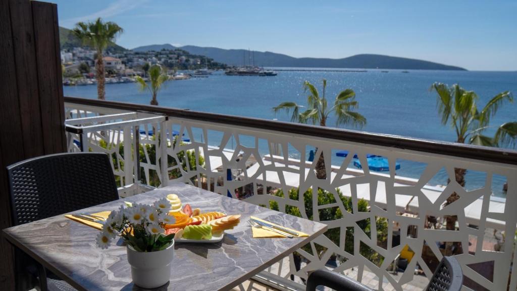 una mesa en un balcón con vistas al océano en Sand Garden Hotel Bodrum en Bodrum