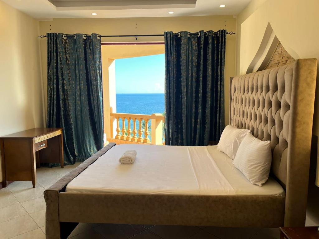 The penthouse beachfront في مومباسا: غرفة نوم مع سرير وإطلالة على المحيط