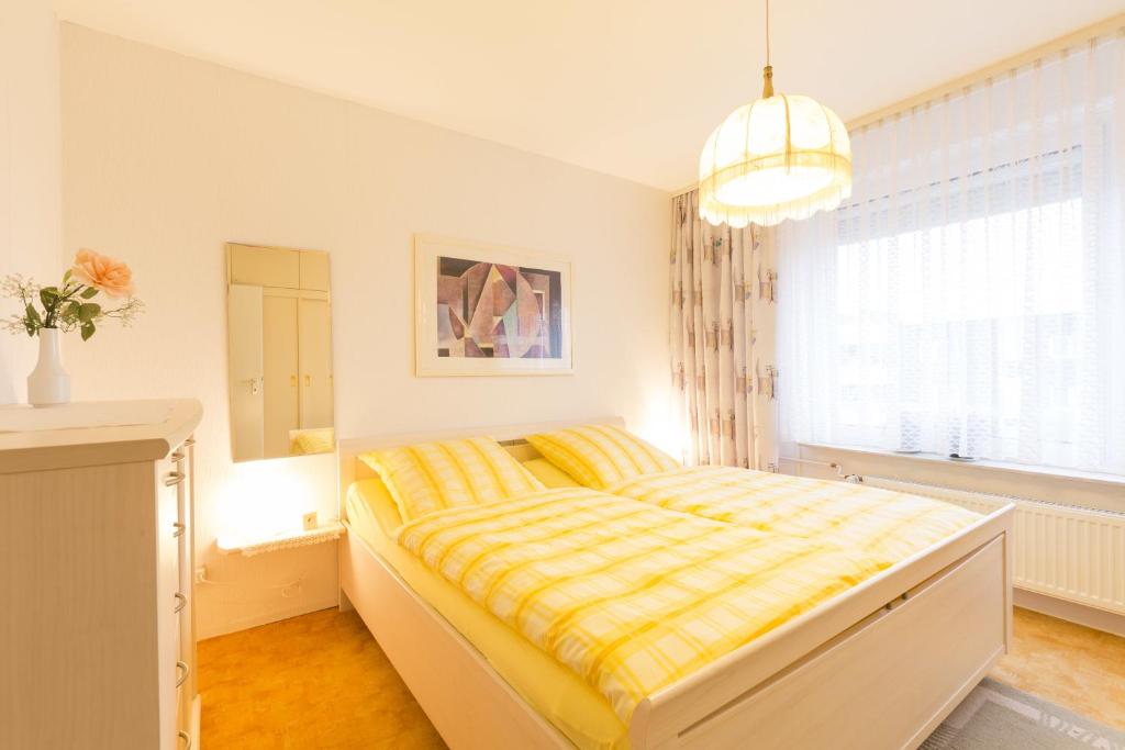 ein Schlafzimmer mit einem Bett mit einer gelben Decke in der Unterkunft Deutsche Messe Zimmer - Private Apartments & Rooms Hannover City - room agency in Hannover