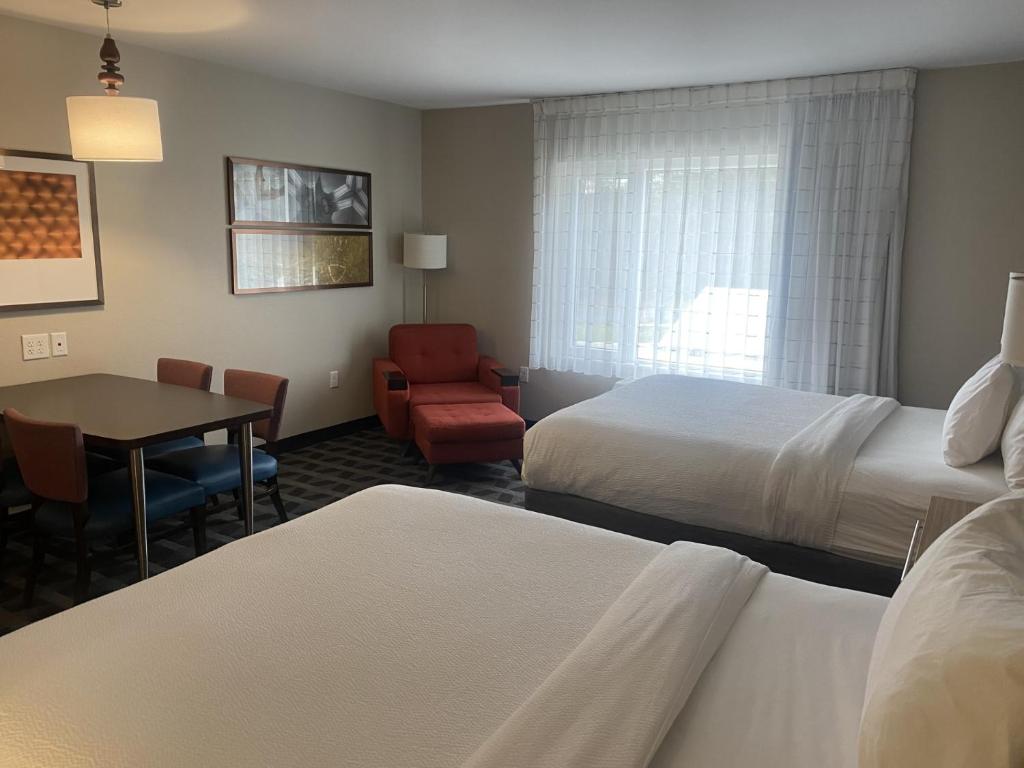 um quarto de hotel com duas camas e uma mesa e uma cadeira em TownePlace Suites by Marriott Edgewood Aberdeen em Belcamp