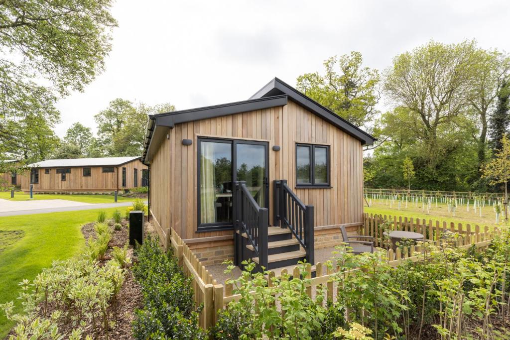 a tiny house with a deck in a garden at Blenheim Palace Lodge Retreat in Woodstock