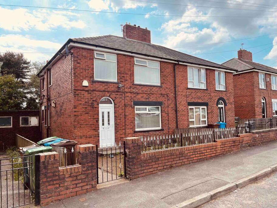 uma casa de tijolos com uma cerca em frente em Entire 3 Bed Home in Oldham em Oldham