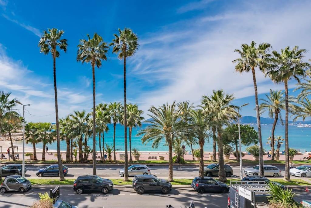 - un parking avec des palmiers et la plage dans l'établissement Cannes Appartement Croisette vue mer, à Cannes