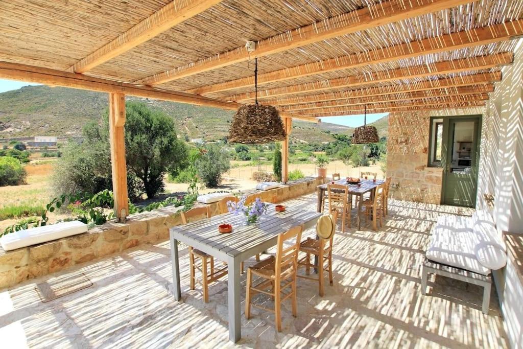 a patio with a table and chairs under a pergola at Oleander Country House in Patmos
