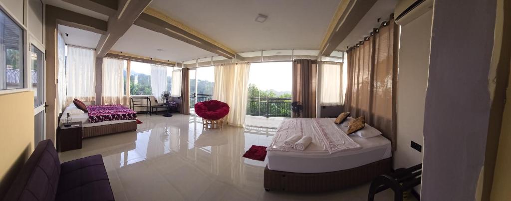 a large room with two beds and a balcony at Eye Catch Kandy in Kandy