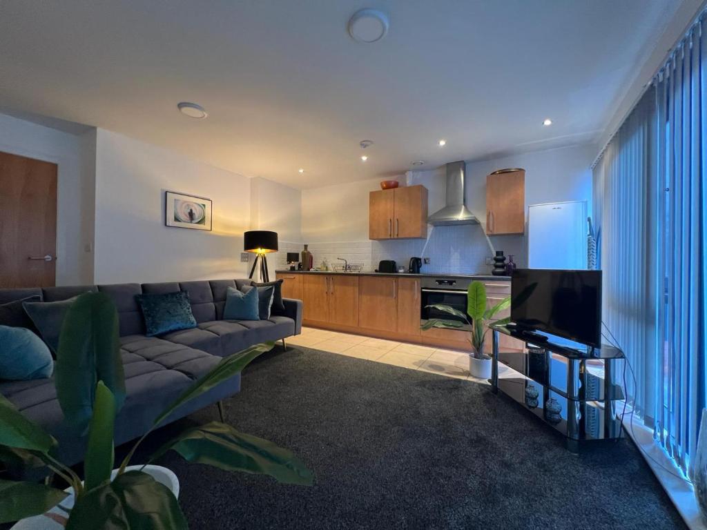 a living room with a couch and a kitchen at Stunning City Centre Apartment, Benson Street, Liverpool 1 in Liverpool
