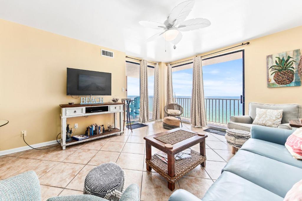 a living room with a couch and a tv at Romar Place Unit 904 in Orange Beach
