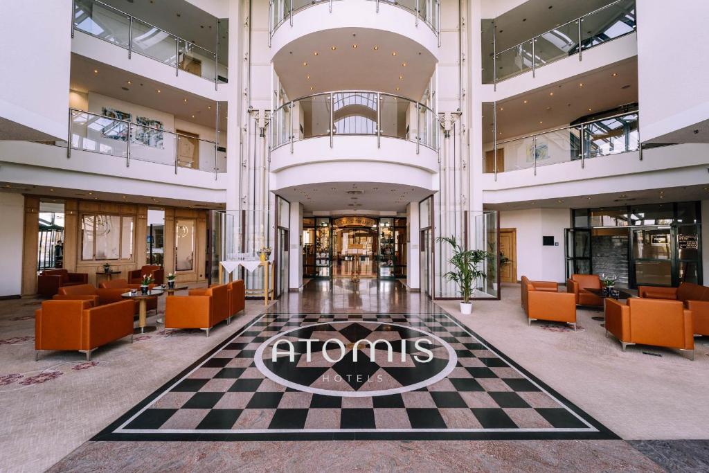 an empty lobby with a sign on a checkered floor at Atomis Hotel Munich Airport by Mercure in Oberding