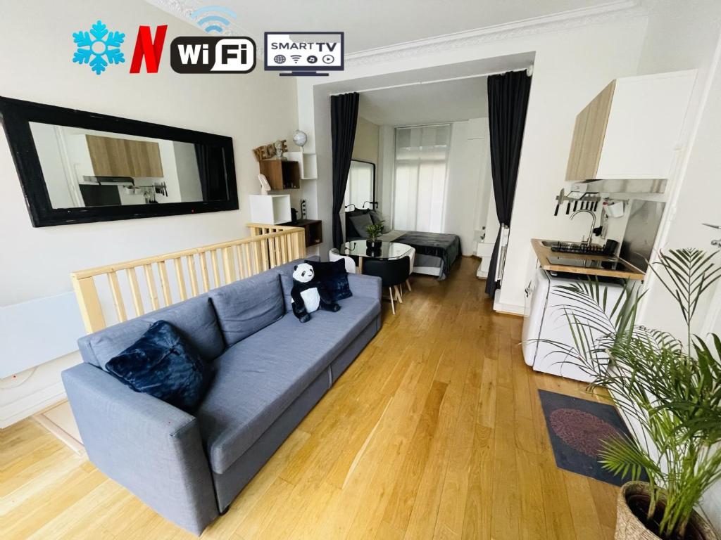 a living room with a blue couch in a room at Le refuge du 15 in Paris