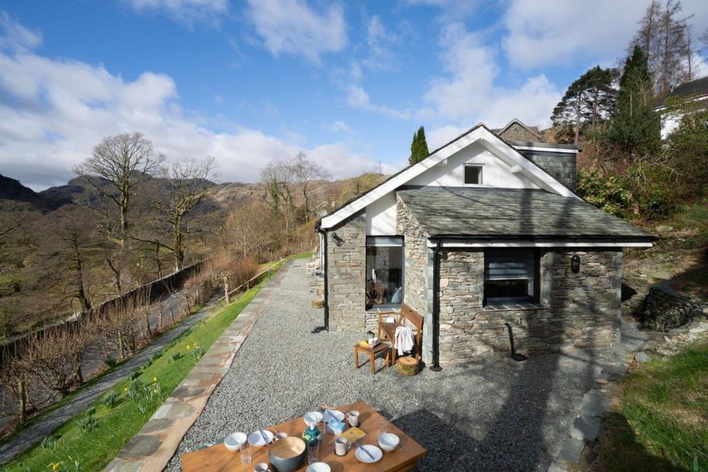 a small stone house with a table and chairs at Serene Retreat in Chapel Stile by LetMeStay in Ambleside