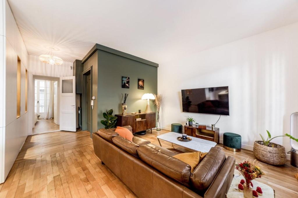 ein Wohnzimmer mit einem Sofa und einem TV in der Unterkunft Elegance and high standing in the city center in Lyon