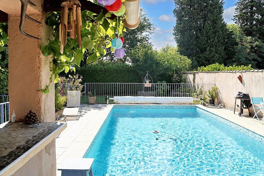 a swimming pool in the backyard of a house at Appartement charmant proche d'Avignon avec piscine privée in Le Pontet