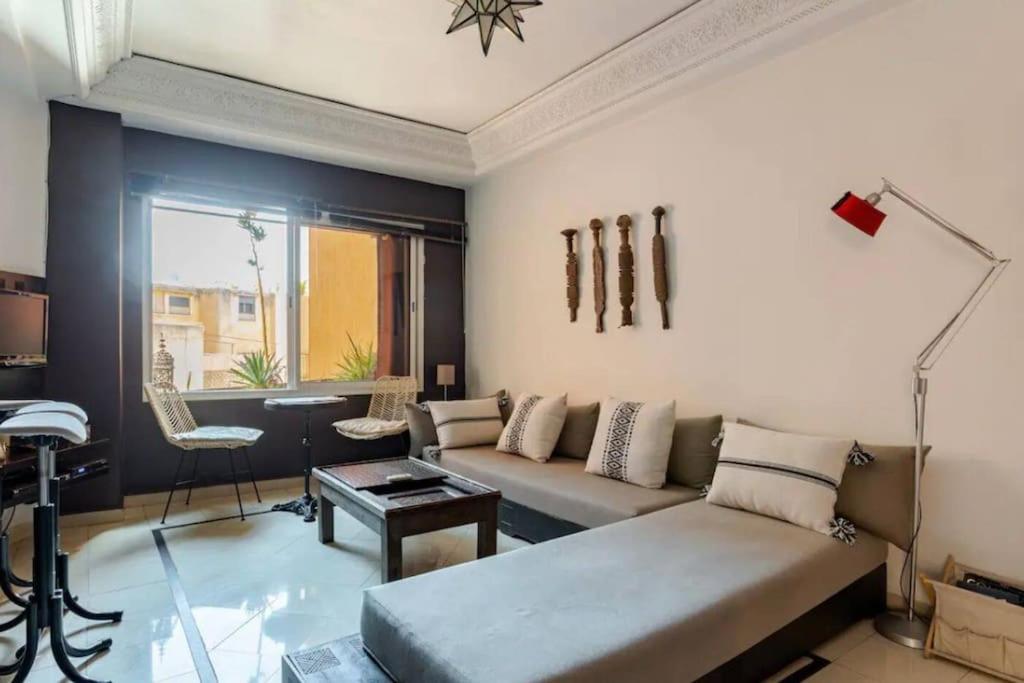 uma sala de estar com um sofá e uma mesa em Joli appartement centre Gueliz em Marrakech