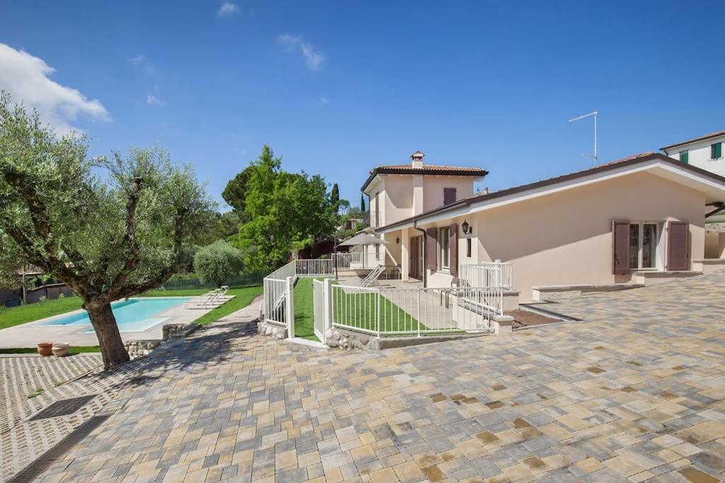 een huis met een hek naast een zwembad bij Villa Chiara APT 2-Appartamento in villa con piscina in Cavaion Veronese