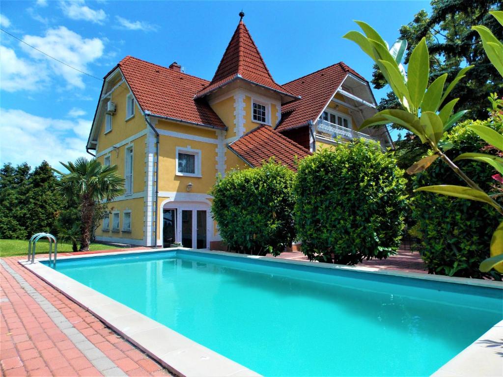 a house with a swimming pool in front of a house at Éden Villa Apartmanház 2 in Balatonfüred