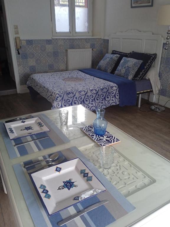 Cette chambre comprend un lit et une table avec de la vaisselle. dans l'établissement Les capucines, à Saint-Brieuc